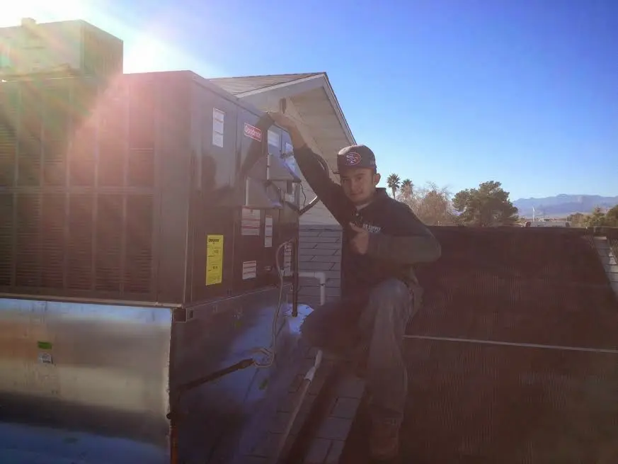 HVAC technician performing Air Duct Repair on a rooftop unit in Herculaneum